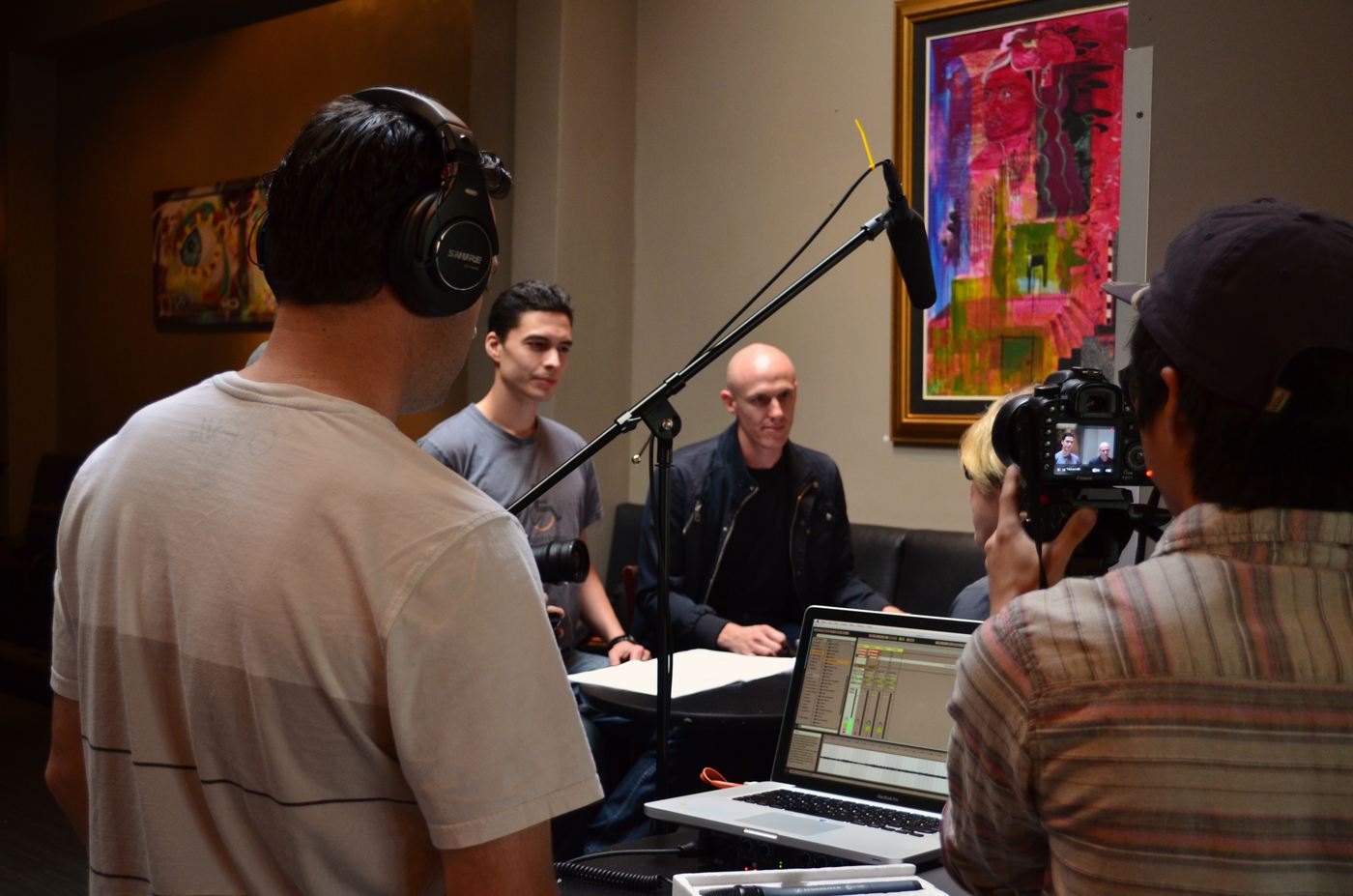 The BEAT casting setup: a sound operator in headphones in the foreground, a camera operator shooting, and two interviewers seated at a table behind a boom mic